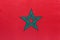 Morocco national fabric flag with emblem, textile background. Symbol of international world african country