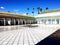 Morocco. Palace El Bahia Marakesh. Interior courtyard with white floor and row of columns on a background of palm trees and blue s