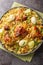 Morog Polao or Bengali Chicken Pulao with boiled eggs and fried onions closeup on the plate on the table. Vertical top view