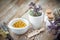 Mortar and bowl of dried healing herbs and bottles of homeopathic globules.