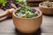 Mortar and different healing herbs on table, closeup