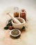 Mortar and pestle with spices and herbs on softly colored canvas table cloth