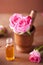 Mortar with rose flowers and essential oil for aromatherapy and