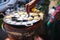 Mortar-toasted pastry on spoon with asian woman hand holding in the hot pan stove , Thai dessert