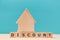 Mortgage. Real estate. Discount on property. Wooden house miniature standing on cubes with letters on blue. Copy space
