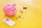 Mortgage. Savings for buy house. Moneybox in shape of pig near keychain in shape of car, coins, calculator on yellow