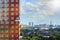 Moscow cityscape with a worker in a construction cradle on the wall of a building under construction lighted by sun rays