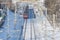 MOSCOW, FEB. 01, 2018: Winter sunny day view on red passenger train coming to railway station people on platform, man on rail trac