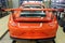 Moscow. February 2019. Back side view of a new orange metallic Porsche 911 GT3 RS in an interactive dealership maintenance box.
