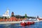 Moscow Kremlin panorama, two ships cruise on the river.