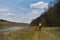 Moscow region, the Moskva River in the countryside on a warm summer sunny day. Man walks with German and Australian Shepherd along