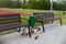 Moscow, Russia - 05/20/2020 - Two benches and lot of trash near the full trash bin. Dirty streets and parks without cleaning