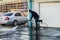 MOSCOW, RUSSIA,APRIL,2.2019:Worker cleans the road from dirt powerful stream of water from the hose