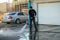 MOSCOW, RUSSIA,APRIL,2.2019:Worker cleans the road from dirt powerful stream of water from the hose