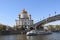 Moscow, Russia - April 29, 2019: River pleasure boat, Patriarchal Pedestrian Bridge, and Cathedral of Christ the Savior.