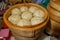 Moscow, Russia - February 25, 2017: National Korean fast food - steamed pies pyan-se in a traditional wooden steamer