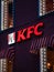 Moscow, Russia - January 17, 2020: KFC logo with red lights on wall of house in evening. Luminous windows with visors made of