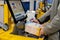 Moscow, Russia - January 7, 2020: A man checks a box of baby food at a self-service checkout counter. Yellow self-service terminal