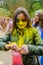 Moscow, Russia - June 3, 2017: Girl, smeared with yellow paint during expressive Holi-battle open pack with pink powder