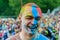 Moscow, Russia - June 3, 2017: Joyfully and broadly laughing guy portrait with face stained with paints of three colors