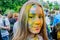 Moscow, Russia - June 3, 2017: Portrait of a teenage girl at festival of colours Holi, face stained with colorful paint