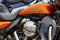 Moscow, Russia - May 04, 2019: Bright orange fuel tank with emblem of Harley Davidson motorcycles and chrome engine closeup. Moto