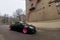 Moscow, Russia - May 08, 2019: A black tuned and understated Volkswagen Golf 6 with bright pink handmade custom wheels stands on