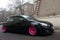 Moscow, Russia - May 08, 2019: A black tuned and understated Volkswagen Golf 6 with bright pink handmade custom wheels stands on