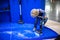 Moscow, Russia - October 04, 2019: cute blonde boy vacuuming blue floor from white crumbs with a new vertical cordless