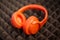 Moscow, Russia - October 04, 2019:  orange  wireless overhead monitor headphones JBL Tune lie on a dark foam rubber noise cancelin