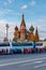 Moscow, Russia - October 08, 2019: Group of tourists walking along parked colored excursion buses against Saint Basil Cathedral on