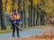 Moscow. Russia. October 11, 2020: A female utility worker uses a blower to remove fallen leaves in an alley in a park