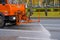 Moscow. Russia. October 11, 2020. An orange heavy truck washes autumn leaves off the asphalt street