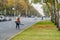 Moscow. Russia. October 11, 2020 A woman utility worker uses a blower to remove fallen leaves on a city street.