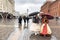 Moscow, Russia, October, 12, 2019. Women in historical costumes walking under an umbrellas on Manezhnaya square in rainy weather i