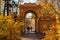 Moscow, Russia - October 17, 2018: Tourists walking under arc of Pavilion Milovida in Tsaritsyno park in Moscow at sunny autumn