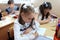 Moscow, Russia - September 1, 2017: Schoolgirls sitting at the desk in class at school, traditional learning, offline education