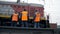 MOSCOW, RUSSIA - SPRING: Railway workers are standing and looking at a passing train. Legs close-up. Worker in orange workwear