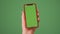 MOSKOW - MARCH 5, 2021: Phone in the hand close up isolated at green background. Phone screen is green chroma key