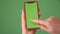 MOSKOW - MARCH 5, 2021: Phone in the hand close up isolated at green background. Phone screen is green chroma key