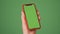 MOSKOW - MARCH 5, 2021: Phone in the hand close up isolated at green background. Phone screen is green chroma key