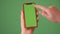 MOSKOW - MARCH 5, 2021: Phone in the hand close up isolated at green background. Phone screen is green chroma key