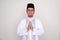 Moslem Asian man smiling at the camera with hand praying pose