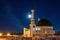 Mosque with a dome and a minaret against the background of the night sky.