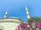 A mosque in flowers against a blue and bright sky. beauty of foreign country, muslim religion. faith in higher powers, stone