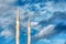 Mosque minaret, loudspeakers and ridge against a vibrant cloudy blue sky background