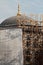 A mosque is under construction and covered with a white tarpaulin