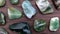 Moss agate rare jewel stones texture on brown varnished wood background. Moving right seamless loop backdrop