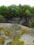 Moss covered rock ledge overlooks gorge crevice below