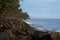 Moss covered rocks and line of coconut trees along the sea shore